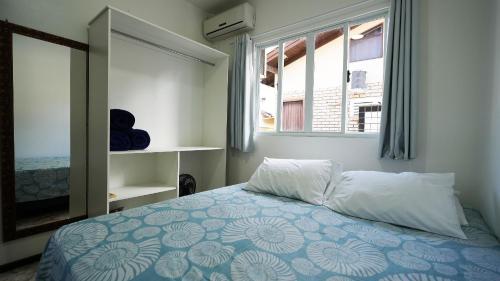 a bedroom with a bed with a blue and white at Residencial Adolfo - Mestre Naro in Bombinhas