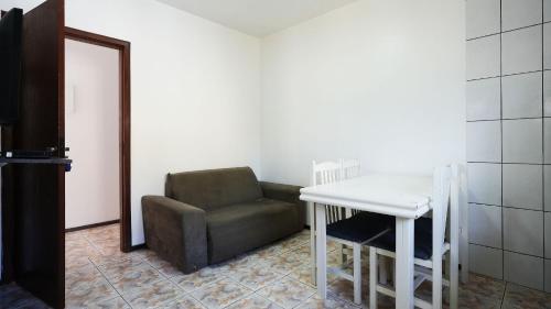 a living room with a chair and a table at Residencial Adolfo - Mestre Naro in Bombinhas