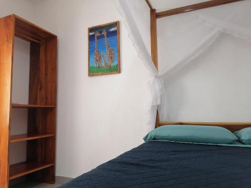 a bedroom with a bed and a picture of giraffes at WIPEOUT SUIT in Puerto López