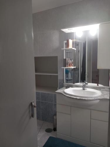 a white bathroom with a sink and a mirror at Casa do Paço com Jardim Privado - Centro de Terras de Bouro, Gerês in Terras de Bouro