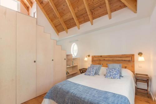 a bedroom with a large white bed with blue pillows at Atelier by Real Vision in Funchal