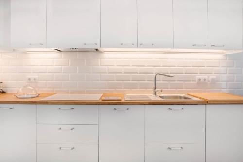a white kitchen with white cabinets and a sink at Atelier by Real Vision in Funchal