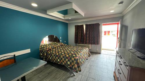 a bedroom with a bed and a tv in it at Hiland Motel in Long Beach