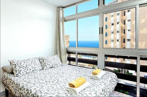 a bed in a room with a large window at Estudio completo piscina y playa en Candelaria Tenerife in Candelaria
