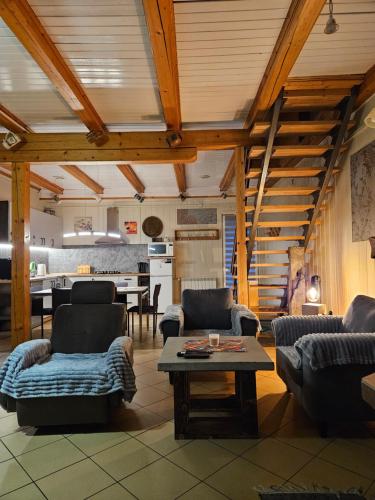 a living room with couches and a table and a kitchen at Domek Domino in Korbielów