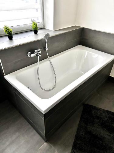 a white bath tub in a bathroom with a window at No 20 - gemütliche 2 Zimmer Whg, Küche, Balkon, Badewanne, Parkplatz in Leinefelde