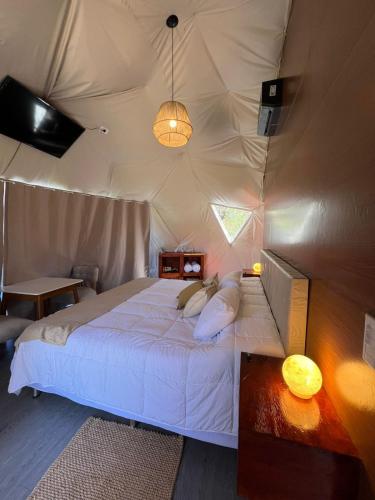 a bedroom with a bed in a tent at GLAMPING CACHI EL PARAISO DE NALA in Cachí