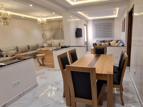 a kitchen and living room with a wooden table and chairs at The Elite suites in Marrakech