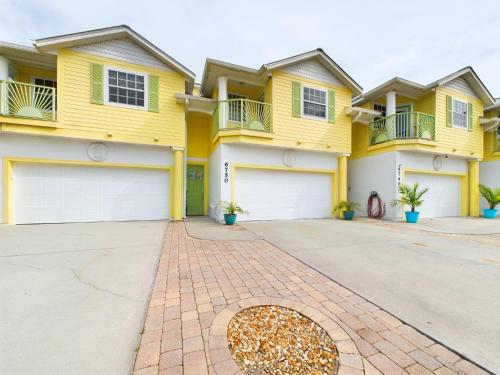 a large yellow house with a driveway at Coastal Bliss Retreat - Beach Vibes & Rockets in Cocoa Beach