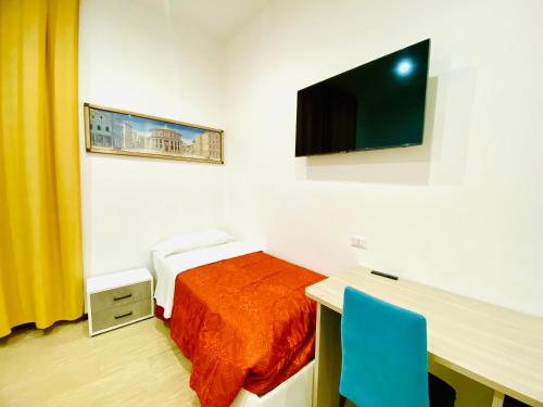 sypialnia z łóżkiem, biurkiem i telewizorem w obiekcie Tawhid Accomodation w Rzymie