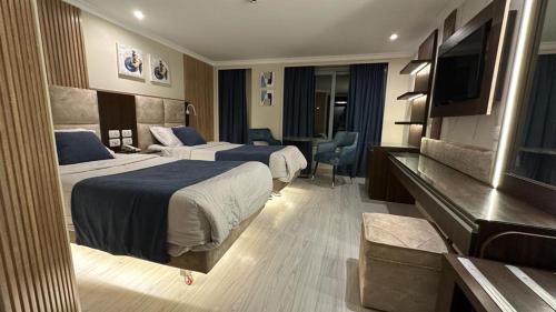 a hotel room with two beds and a flat screen tv at Nile Cruise 3 & 4 & 7 Nights in Luxor