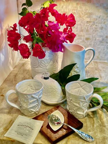 a table with vases and red flowers on it at Kaanapali's Royal Luxury Plantation Beach & Golf Retreat in Kaanapali
