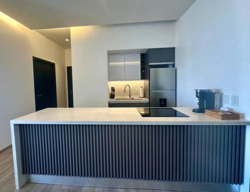 a kitchen with a counter with a sink and a refrigerator at Exclusive Luxury Condo 2bd in Tijuana