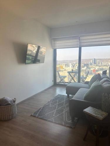 a living room with a couch and a large window at Exclusive Luxury Condo 2bd in Tijuana