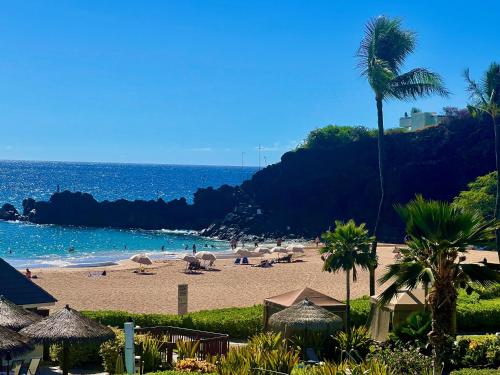 a beach with umbrellas and people on the beach at Kaanapali's Royal Luxury Plantation Beach & Golf Retreat in Kaanapali