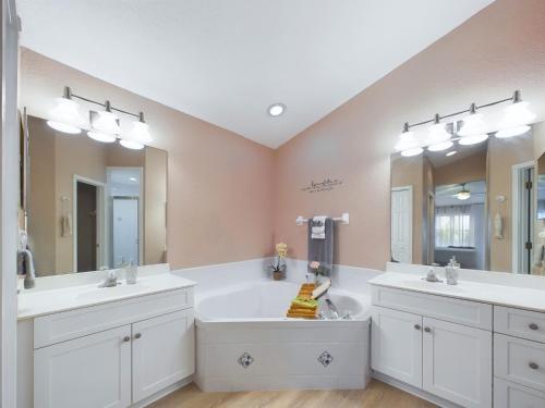 a bathroom with two sinks and a large mirror at Coastal Bliss Retreat - Beach Vibes & Rockets in Cocoa Beach