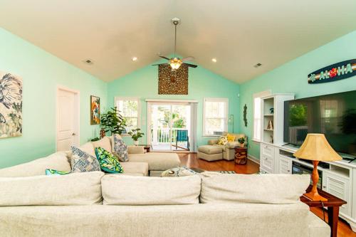 a living room with a white couch and blue walls at Aloha Breeze Pet Friendly House Near Beach in Myrtle Beach