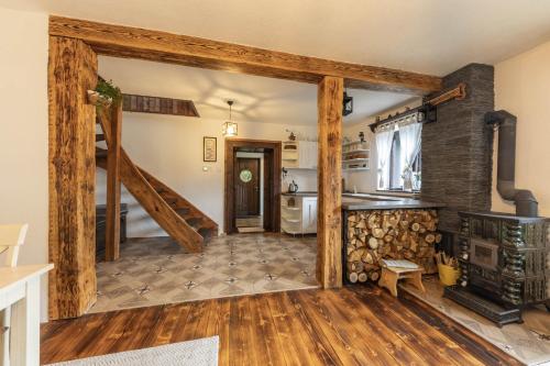 a living room with a staircase and a kitchen at Chalúpka Polom in Hnúšťa