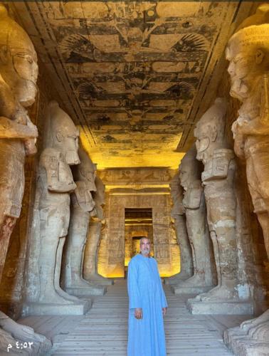 a man in a blue robe standing in a temple at Osiris Guest House in Abu Simbel
