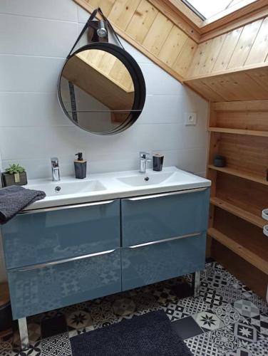 une salle de bain avec un lavabo bleu et un miroir dans l'établissement Chalet Vosges La Bresse, à La Bresse