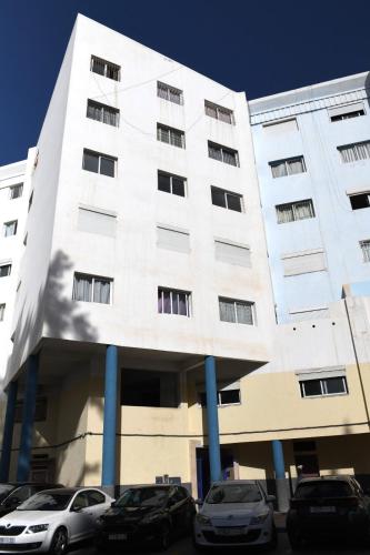 a white building with cars parked in front of it at Appartment Jamila a Agadir in Agadir