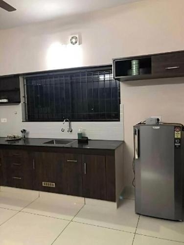 a kitchen with a stainless steel refrigerator and a sink at Urbane Cove in Trivandrum