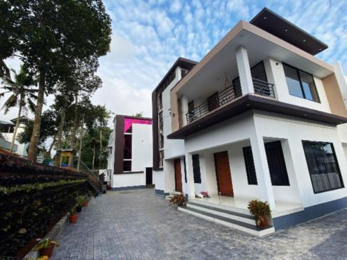 a house with a pathway in front of it at Urbane Cove in Trivandrum