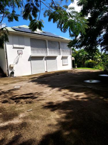 a white building with a basketball hoop at La tranquillité in Les Abymes