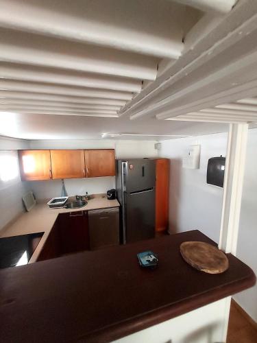 a small kitchen with a table and a refrigerator at La tranquillité in Les Abymes