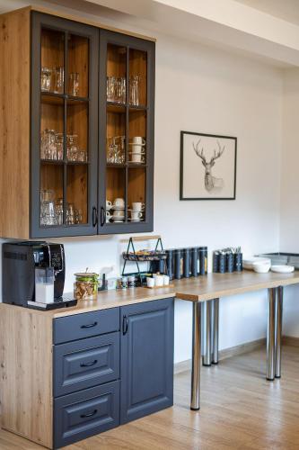 a kitchen with a wooden counter and a blue cabinet at Pod Gromadzyniem Resort in Ustrzyki Dolne