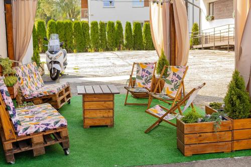 patio z krzesłami, stołem i motocyklem w obiekcie Pod Gromadzyniem Resort w mieście Ustrzyki Dolne