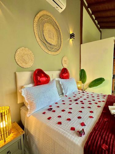 a bedroom with a bed with red decorations on it at Chalé Tucano super Luxo in Cunha