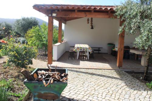 a patio with a table and a table and a bench at Quinta de São João in Poios