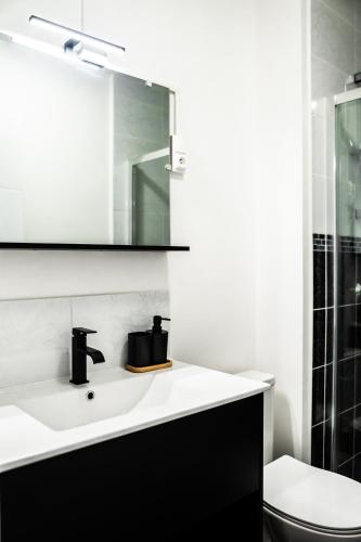 une salle de bain avec un lavabo, des toilettes et un miroir dans l'établissement La Shekinah-Chambre dorée, au Creusot