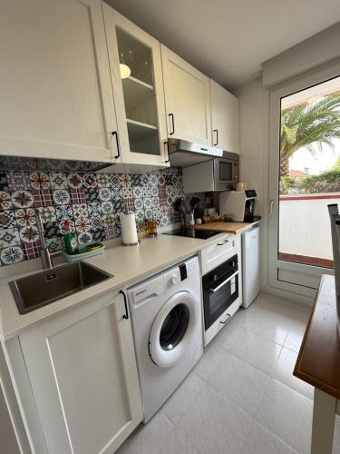 a kitchen with a washing machine and a sink at Apartamento con terraza en Mogro Playa de Usil in Mogro