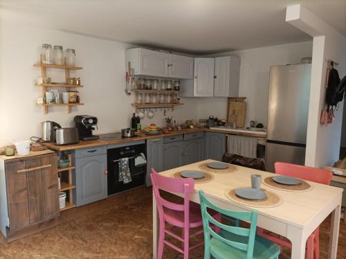a kitchen with a table and chairs and a refrigerator at Chemin de résilience, séjours détente et nature in Fouchy