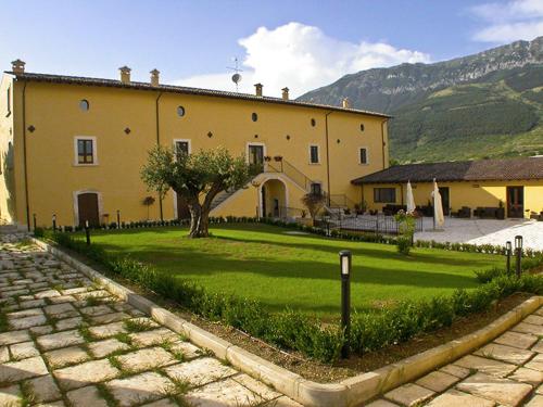 a large yellow house with a green lawn in front of it at Villa Giovina in Pratola Peligna