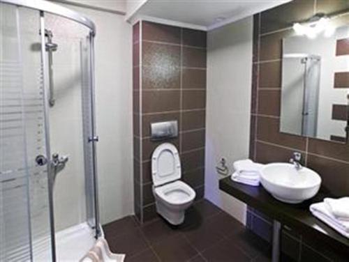 a bathroom with a toilet and a sink and a shower at Veriopolis Hotel in Veria