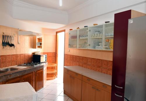 a kitchen with wooden cabinets and a counter top at Appartment Jamila a Agadir in Agadir