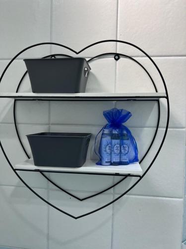 a glass shelf with dishes and a heart on a wall at Casa Vacanza IMPARO B&B Ischia in Ischia