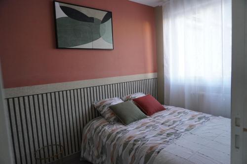 une chambre avec un lit avec deux oreillers dessus dans l'établissement Le Minck, à Calais