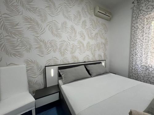 a small bedroom with a white bed and a wall at Casa Vacanza IMPARO B&B Ischia in Ischia