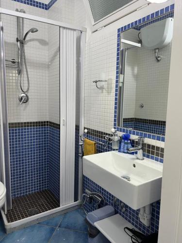 a blue and white bathroom with a sink and a shower at Casa Vacanza IMPARO B&B Ischia in Ischia