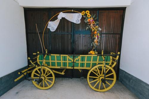 a yellow and green carriage parked next to a building at Studio apartman Ivana in Gradište