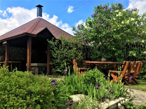 a building with a table and chairs in a garden at Zeleny Dom Vysoké Tatry in Stará Lesná