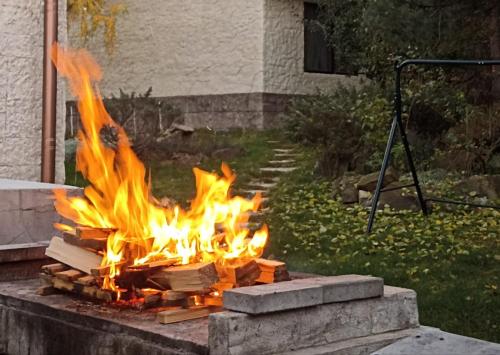 a fire pit in a yard with flames at Bellevue Beam House in Covasna