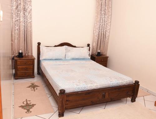 Un dormitorio con una cama y dos mesitas de noche. en Agadir-Apartment, en Agadir