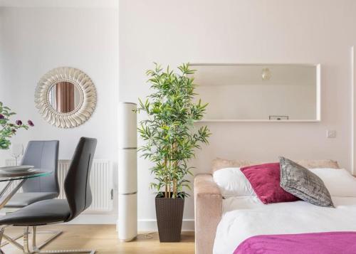 a bedroom with a bed and a chair and a plant at Castle Haven, Redhill in Redhill