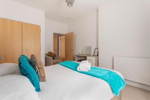 a bedroom with a large white bed with blue sheets at Castle Haven, Redhill in Redhill