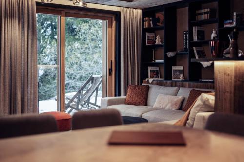 un salon avec un canapé et une grande fenêtre dans l'établissement Antarès URSA 002 - luxury apartment ski inski out, à Méribel